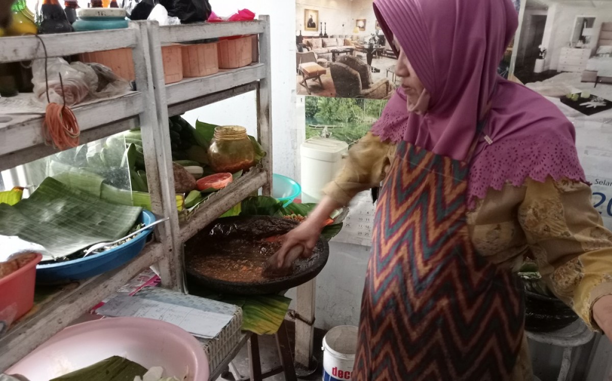 Bu Bokin sedang mengolah rujak cingur. (Foto: Elok Aprianto/jatimnow.com)