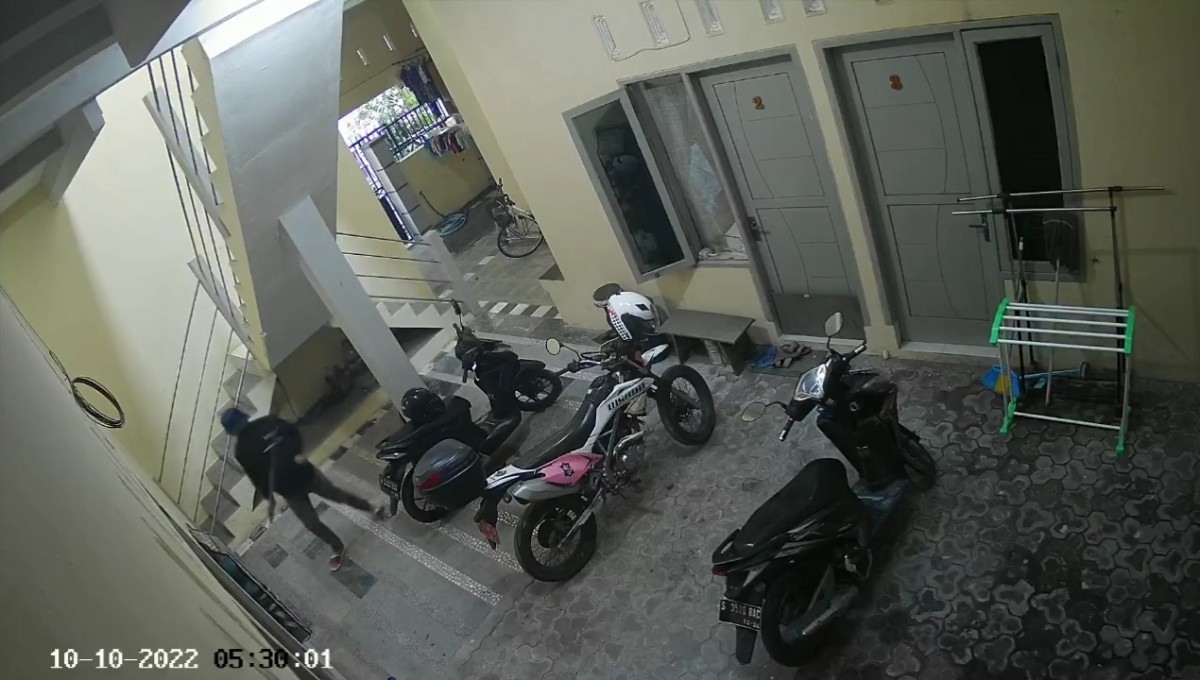 Pelaku saat terekam CCTV masuk ke kos berjalan pincang dengan membawa tongkat kayu. (Foto: Tangkapan layar video CCTV)