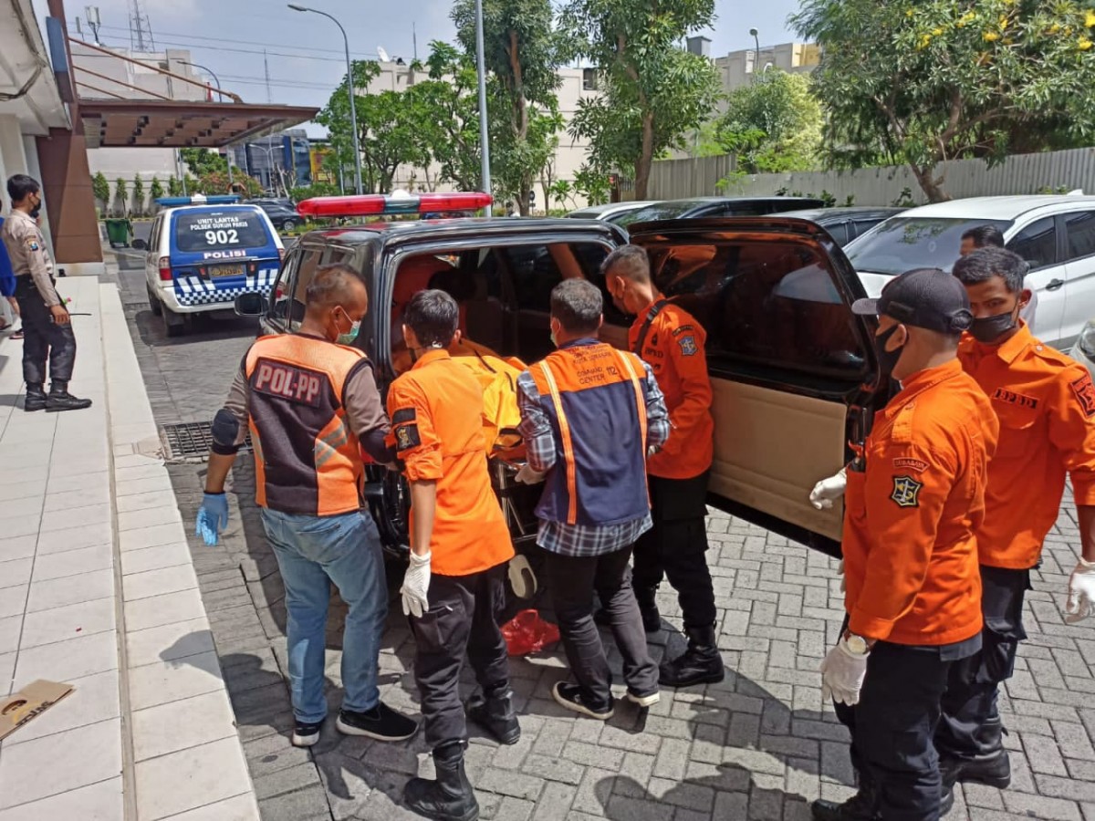 Evakuasi jenazah pria yang loncat dari lantai 28 apartemen di Surabaya (Foto: Polsek Dukuh Pakis)