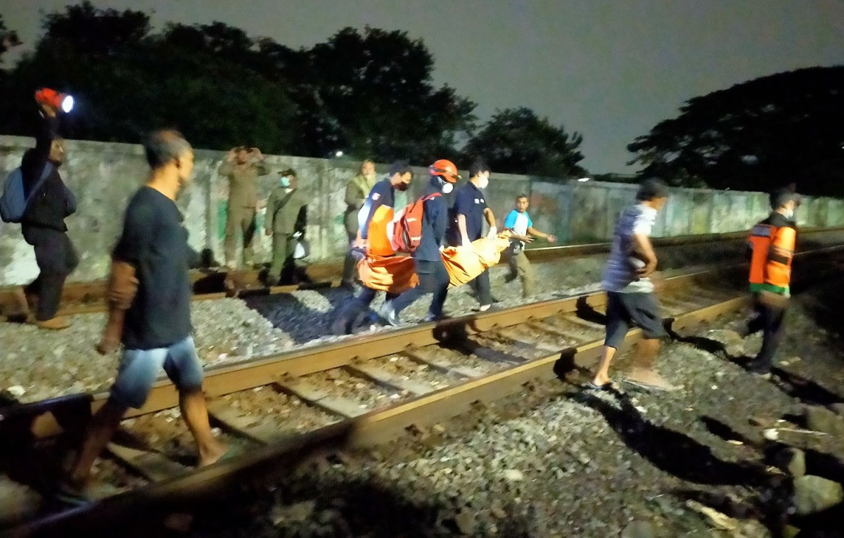 Proses evakuasi jasad bocah 11 tahun yang tertabrak kereta api di Surabaya (Foto: Fahrizal Tito/jatimnow.com)
