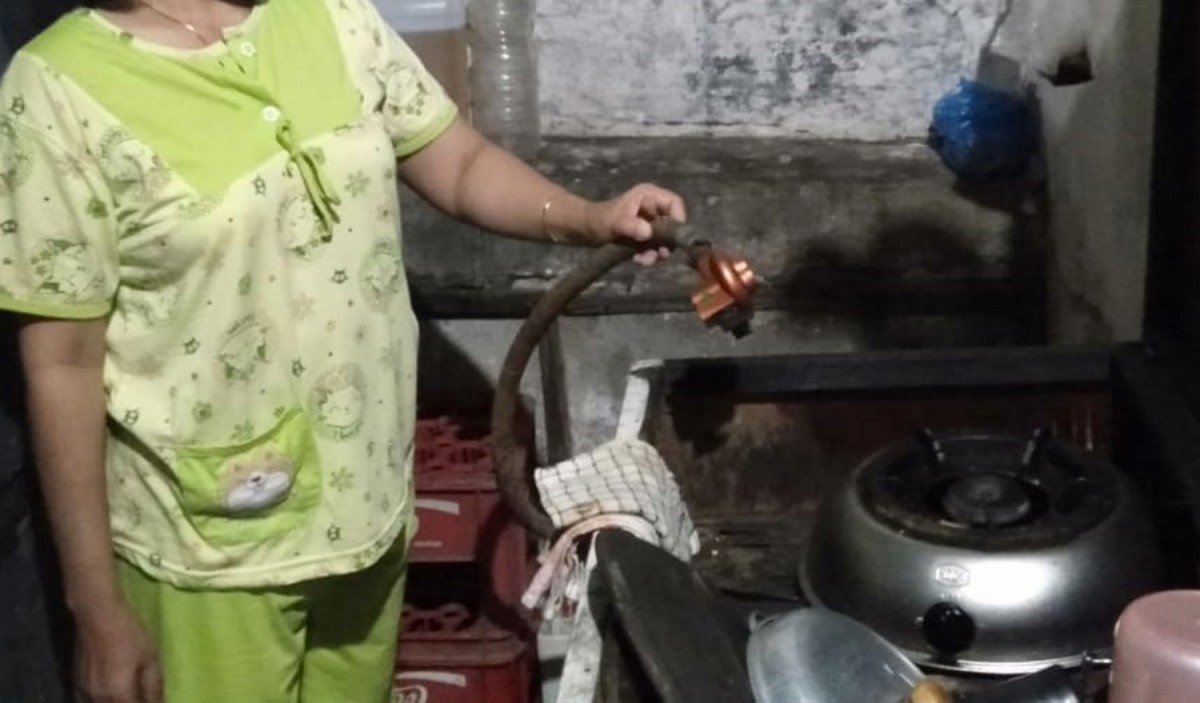 SS, salah penghuni kos di Jalan Raya Rungkut Kidul Surabaya, yang juga karyawan pabrik rokok di kawasan SIER, menunjukkan selang dari elpijinya yang dicuri maling (Foto: Dofir for jatimnow.com)