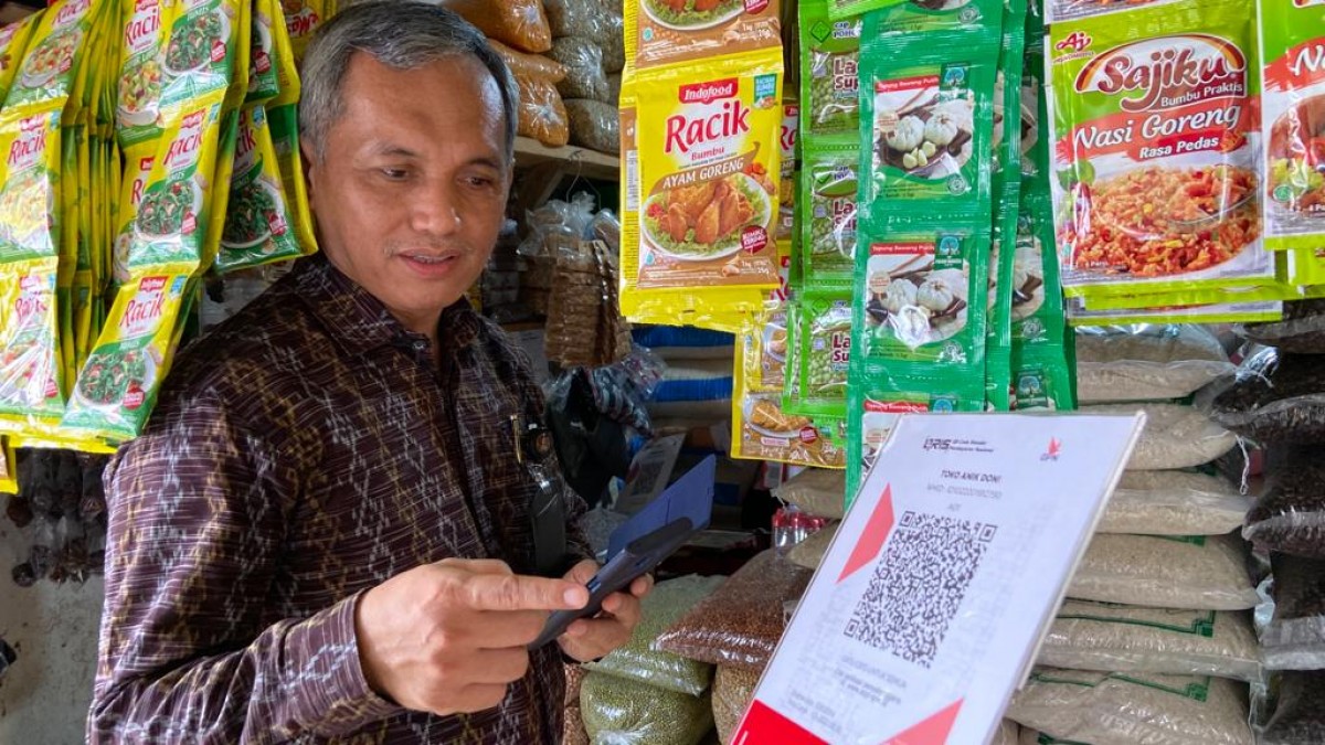 Kepala Bank Indonesia Kediri, M Choirur Rofiq mencoba transaksi menggunakan QRIS di Pasar Pamenang Pare. (Foto: Yanuar Dedy/jatimnow.com)