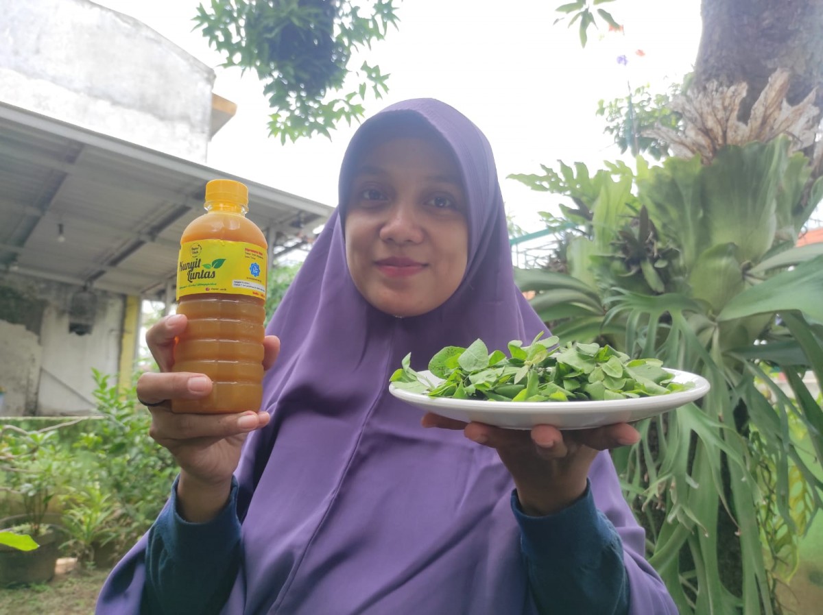 Aprilia Dwi Pravitasari saat memamerkan minuman kunyit luntas yang ia jual. (foto: Nor for jatimnow.com)