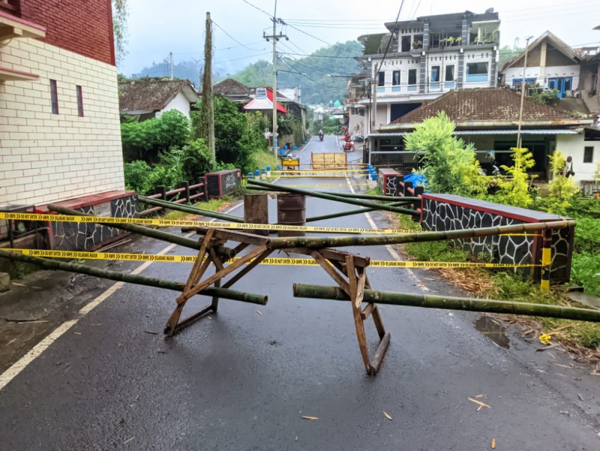 Jembatan di Jalan Gunungsari Talangrejo, Desa Gunungsari, Kecamatan Bumiaji, Kota Batu ditutup warga akibat kikisan air hujan di bagian pondasi (foto: Galih Rakasiwi/jatimnow.com)
