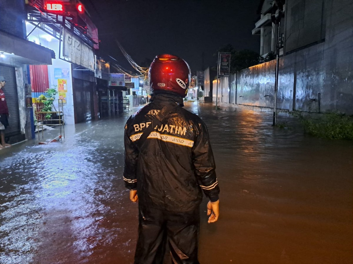 Petugas mengawasi jalan alternatif Peterongan-Jombang yang ditutup sementara akibat banjir setinggi 60 CM setelah hujan deras. (foto: Elok Aprianto/jatimnow.com)