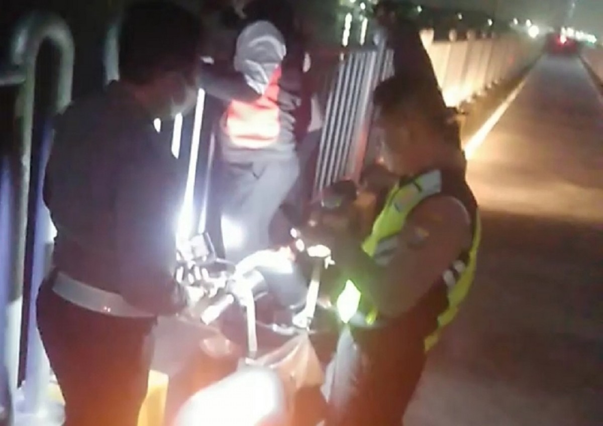 Polisi saat melakukan pemeriksaan terhadap motor misterius yang ditinggalkan pemiliknya di Jembatan Suramadu. (Foto: Polsek Kenjeran for jatimnow.com)
