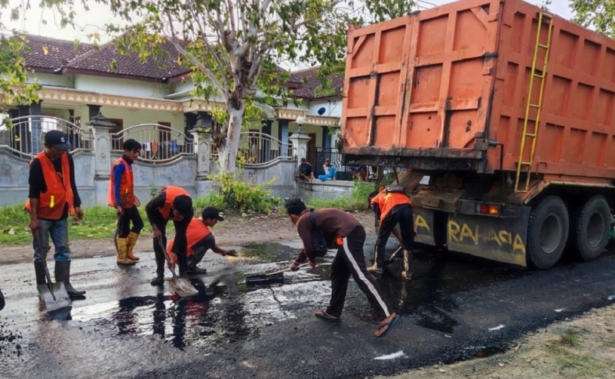 Petugas melaksanakan pengaspalan jalan di Ponorogo. (Foto: Mita Kusuma/jatimnow.com)