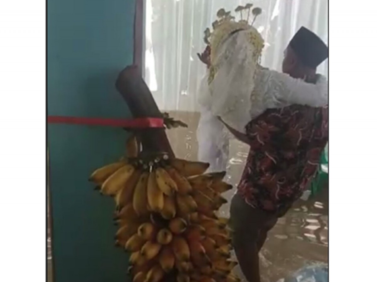 Pengantin wanita digendong untuk melewati air yang menggenangi tenda resepsi pernikahan di Bojonegoro (Foto: Tangkapan layar video amatir warga)