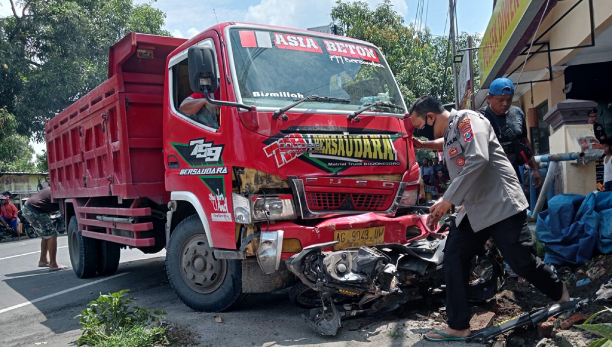 Petugas polisi Polsek Diwek Jombang melihat kondisi truk tanpa muatan yang menggasak dua motor. (foto: Elok Aprianto/jatimnow.com)