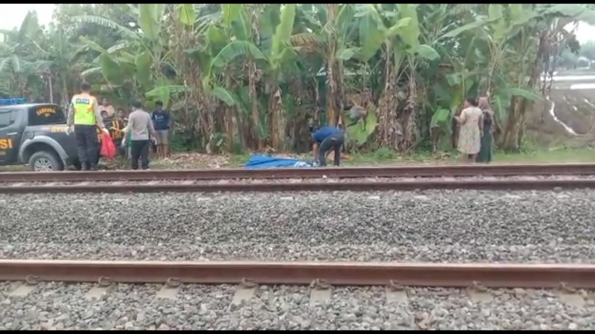 Polisi dibantu warga melakukan evakuasi korban tersambar KA Ambarawa di Bojonegoro. (foto: Misbahul Munir/jatimnow.com)