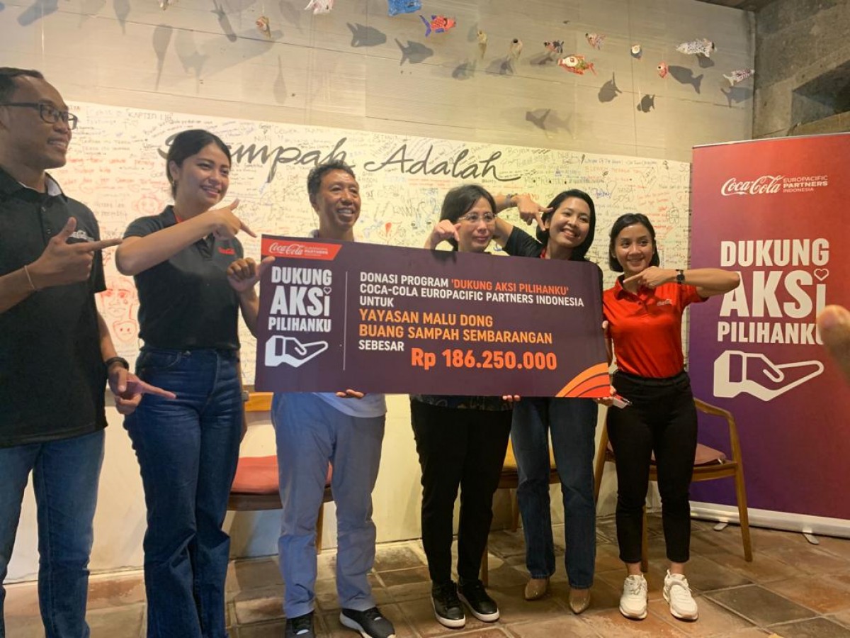 Direktur Public Affairs, Communications & Sustainability CCEP Indonesia Lucia Karina menyerahkan donasi pada Komang Sudiarta, pendiri Yayasan Malu Dong Buang Sampah Sembarangan, di Bali pada 4 November 2022. (CCEP for jatimnow.com)