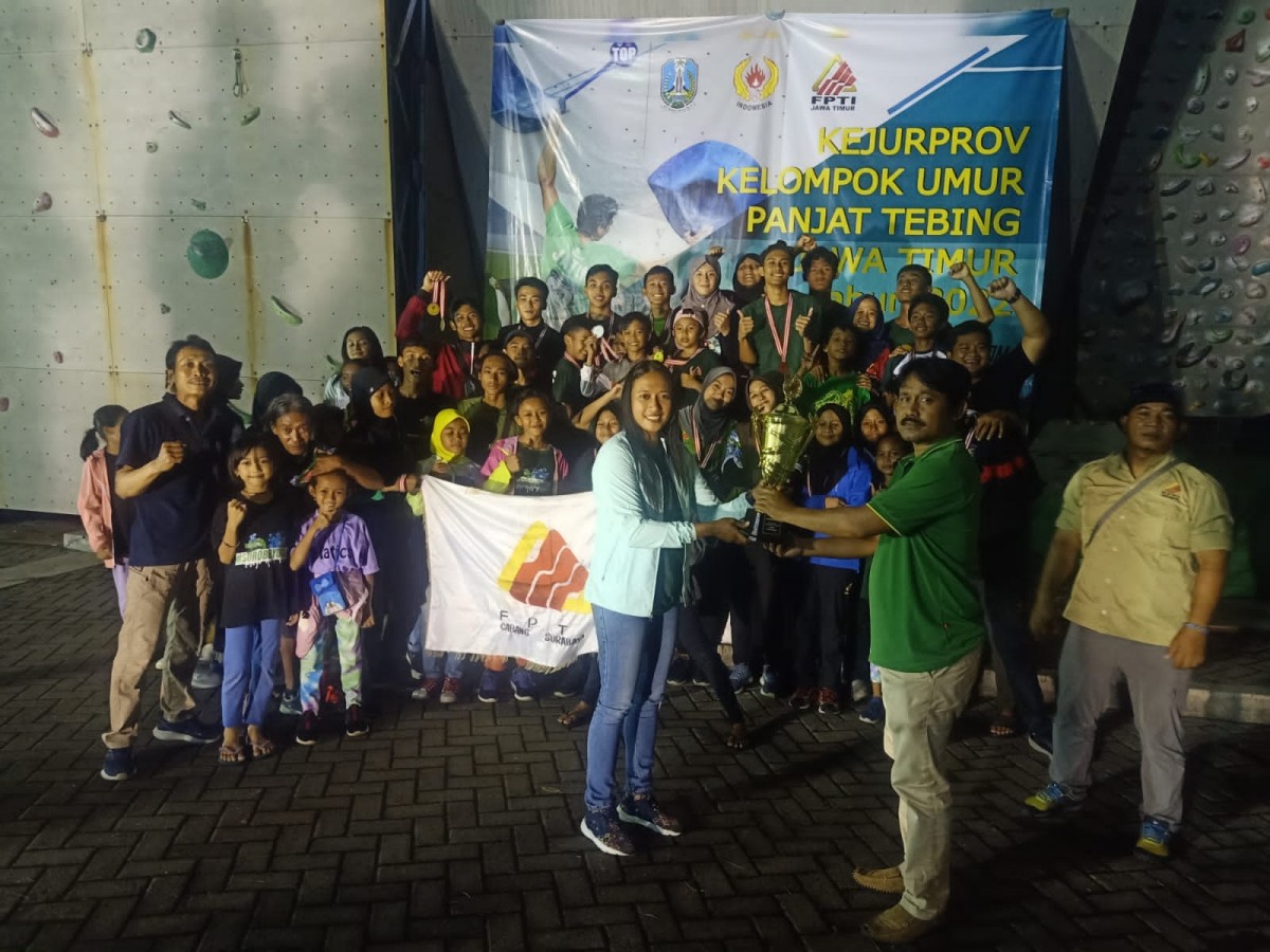 Ketua Umum FPTI Jatim, Dhanu Iswara menyerahkan trofi juara umum kepada FPTI Surabaya. (foto FPTI Jatim for jatimnow.com)