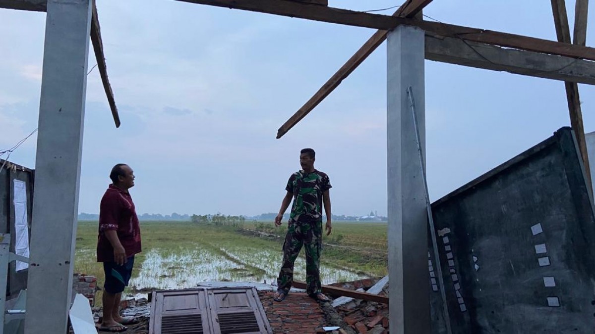 Petugas membantu warga merenovasi rumah yang rusak akibat diterpa angin kencang. (foto: Zainul Fajar/jatimnow.com)