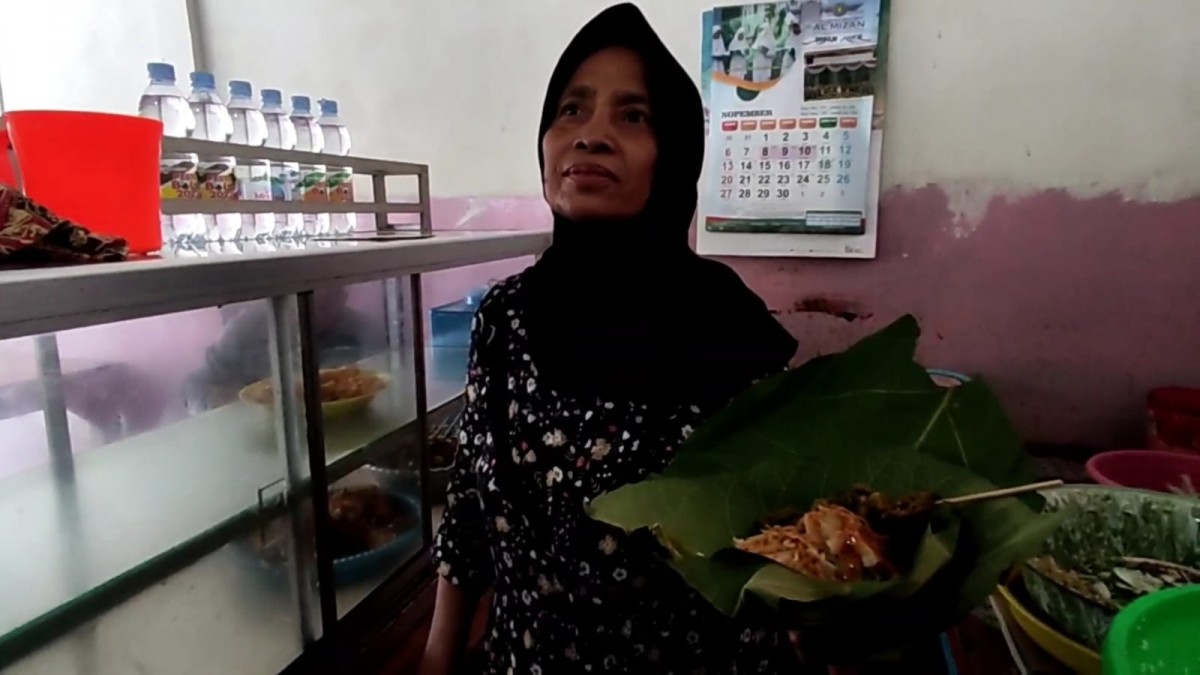 Mak Muafah, penjual nasi pecel pincuk daun jati di Kecamatan Modo, Lamongan. (Foto : Adyad Ammy Iffansah/jatimnow.com)