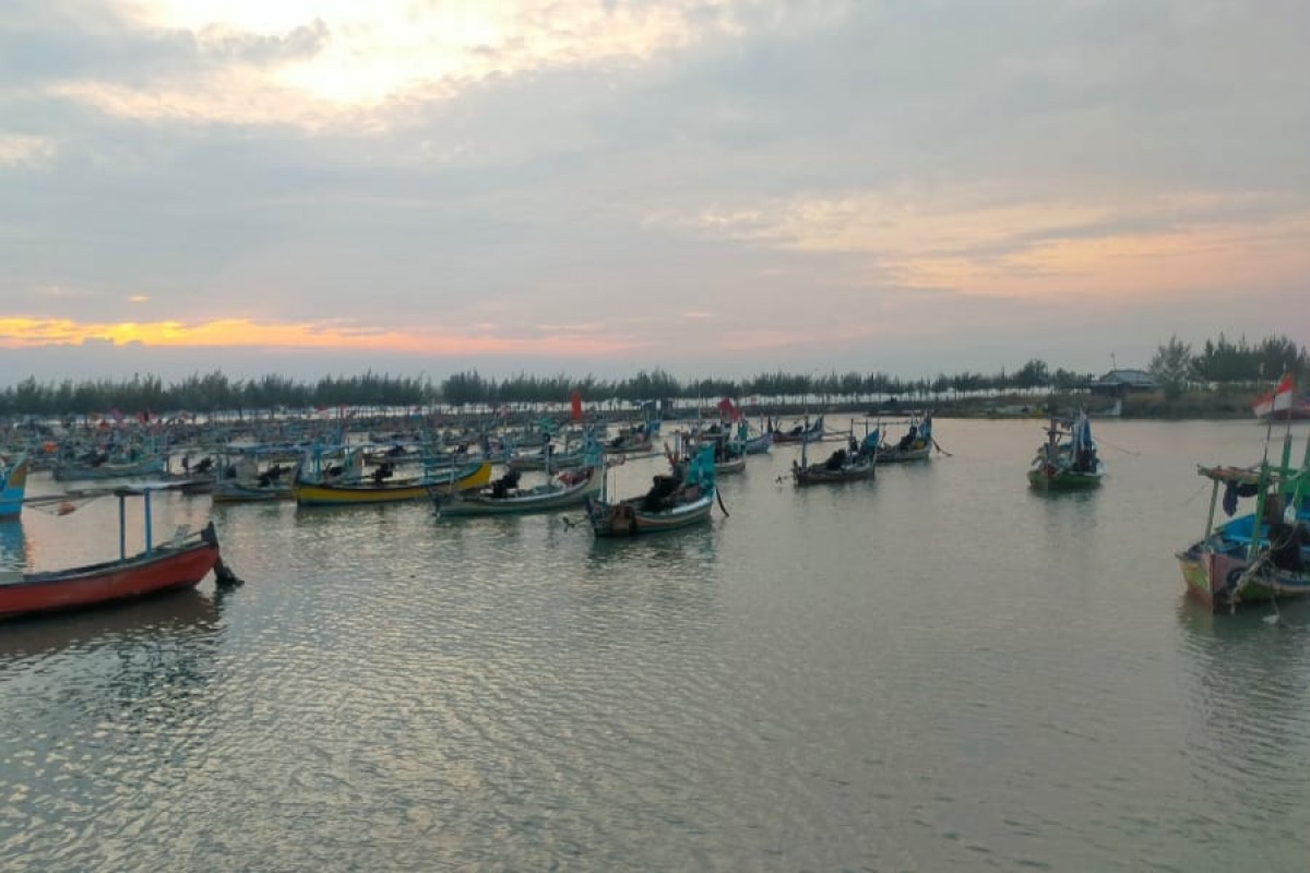 Nelayan akan terus memantau perahu yang sandar lantaran tingginya ombak. (foto : Adyad Ammy Iffansah/jatimnow.com)