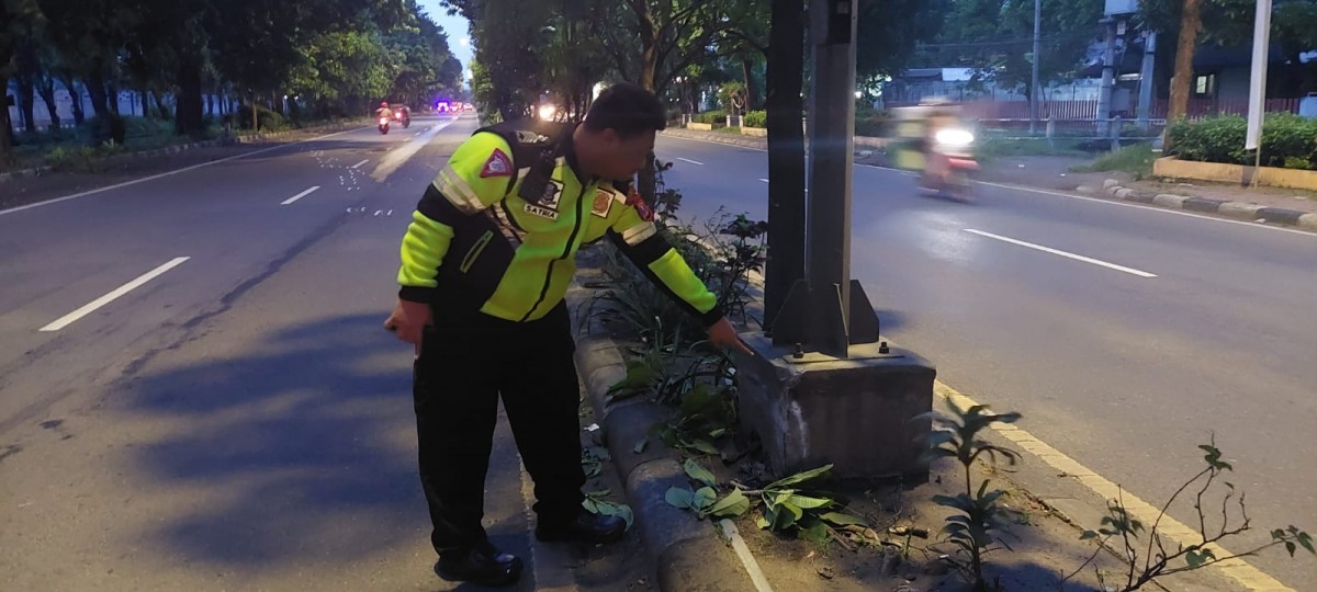 Petugas menunjukkan lokasi tempat kepala korban terbentur saat kecelakaan Jumat (30/12/2022) dini hari WIB. (foto: Unit Gakku Satlantas Polresta Sidoarjo for jatimnow)
