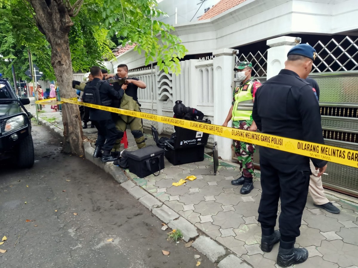 Anggota kepolisian melakukan pemeriksaan dan memasang garis polisi atas munculnya paket misterius di Sidoarjo. (foto: Hutabarat for jatimnow.com)