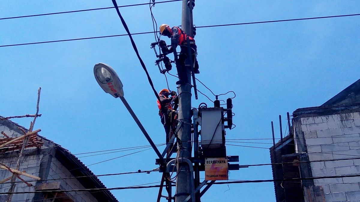 Petugas melakukan perawatan instalasi di salah satu jaringan di kawasan Surabaya. (foto: Rochman Arief)