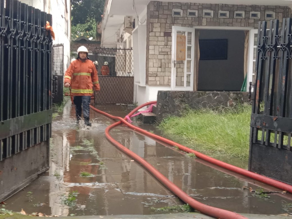 Petugas saat melakukan pembasahan di rumah klasik di Jalan Dr Soetomo Surabaya yang terbakar (Foto-foto: Rama Indra/jatimnow.com)