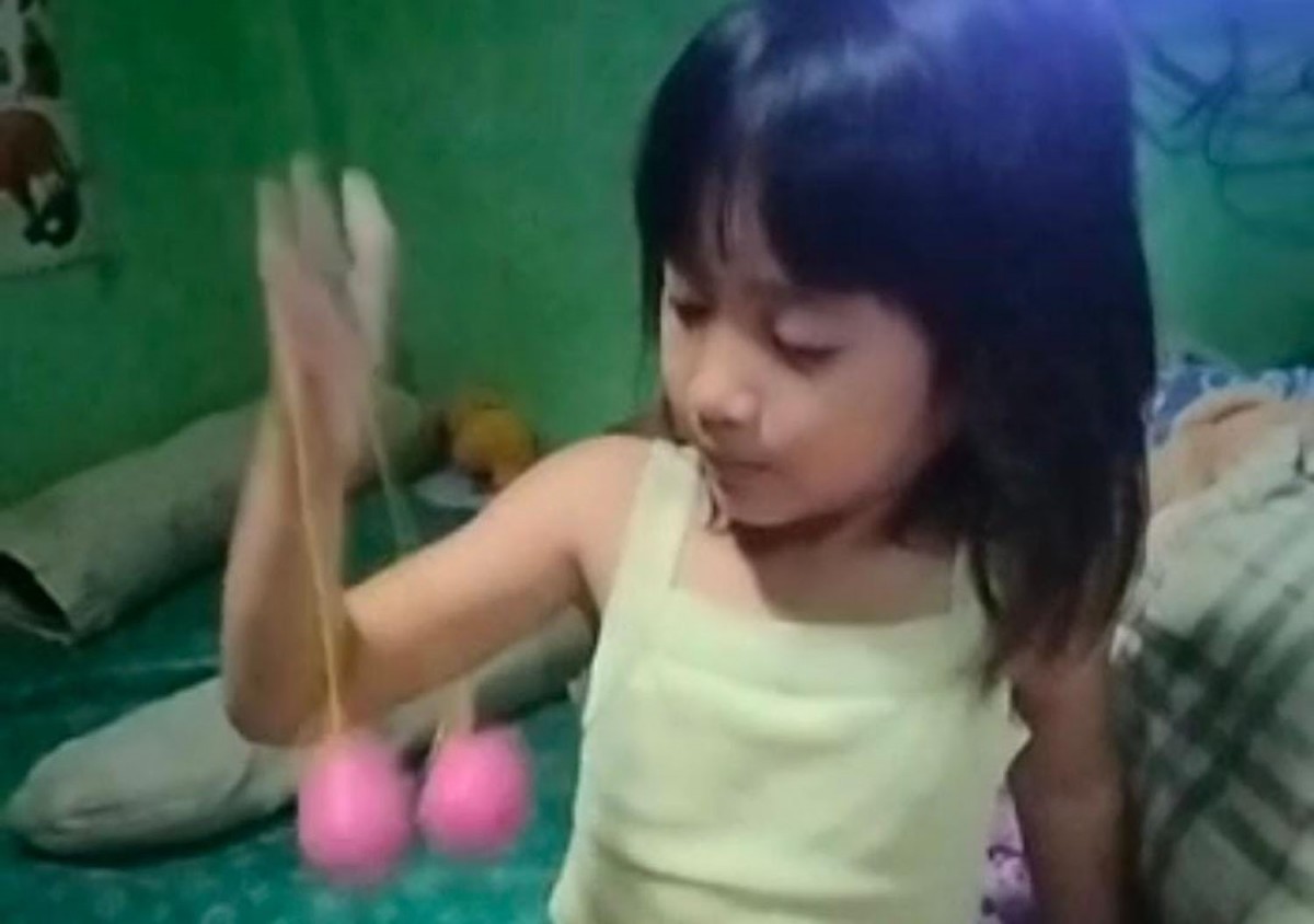 Seorang anak sedang bermain latto-latto (Foto: Ryan for jatimnow.com)