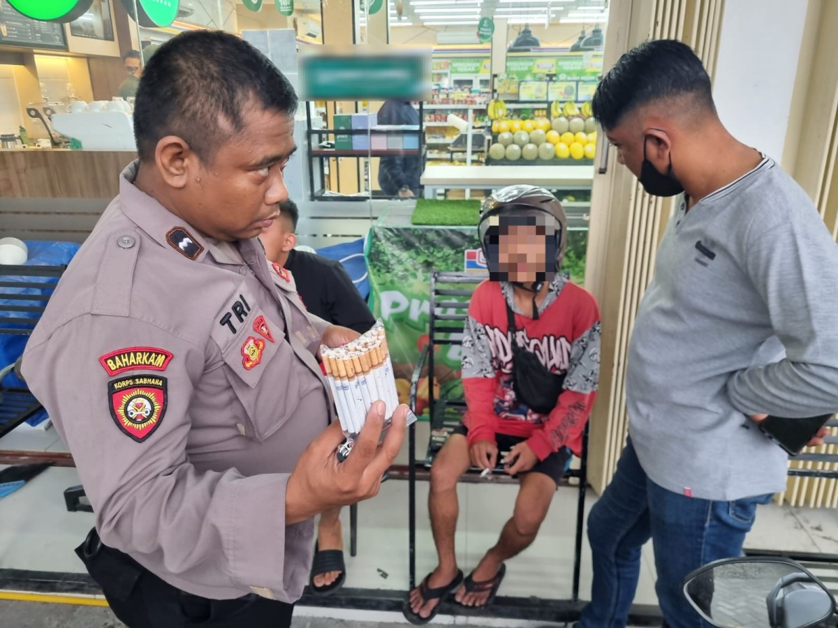 Polisi saat mengamankan pemuda asal Sidoarjo karena menjual rokok tanpa cukai. (Foto: Humas Polres Mojokerto Kota for jatimnow.com)