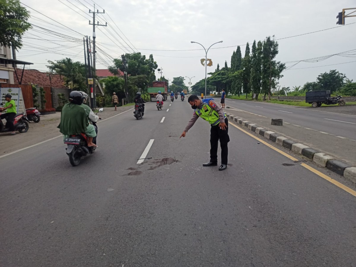 Polisi saat melakukan evakuasi dan olah TKP pengendara tewas terlindas truk. (foto : Unit Gakkum Polres Lamongan for jatimnow.com)