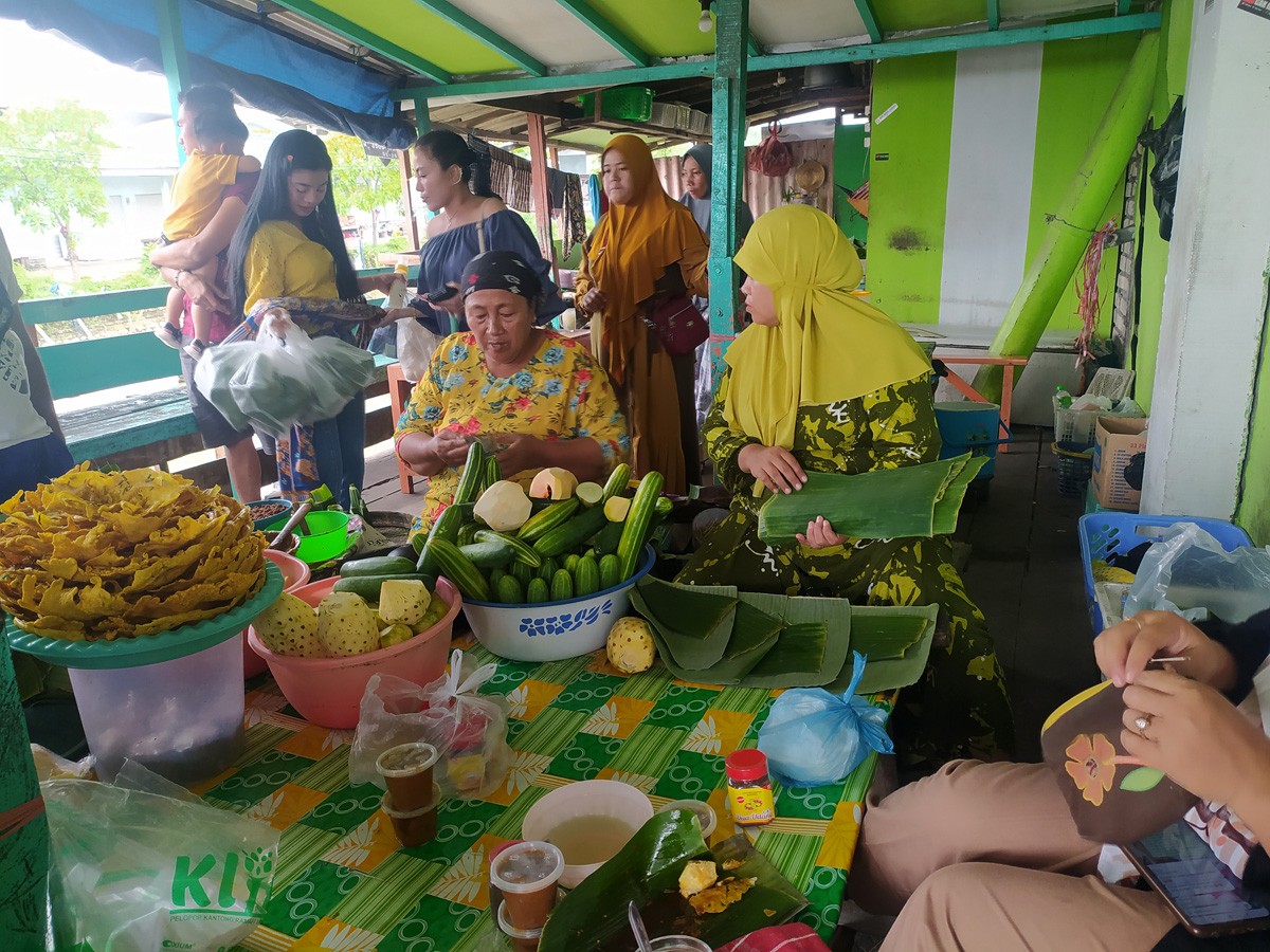 Mak Tas di sela melayani pembeli rujak, dibantu dua pegawai. (foto : Adyad Ammy Iffansah/jatimnow.com)