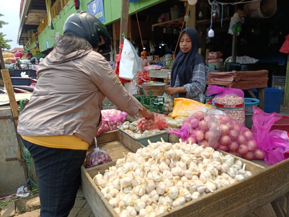 Pedagang Pasar Keputran Utara, Mufaroh saat melayani pembeli. (foto: Rama Indra/jatimnow)
