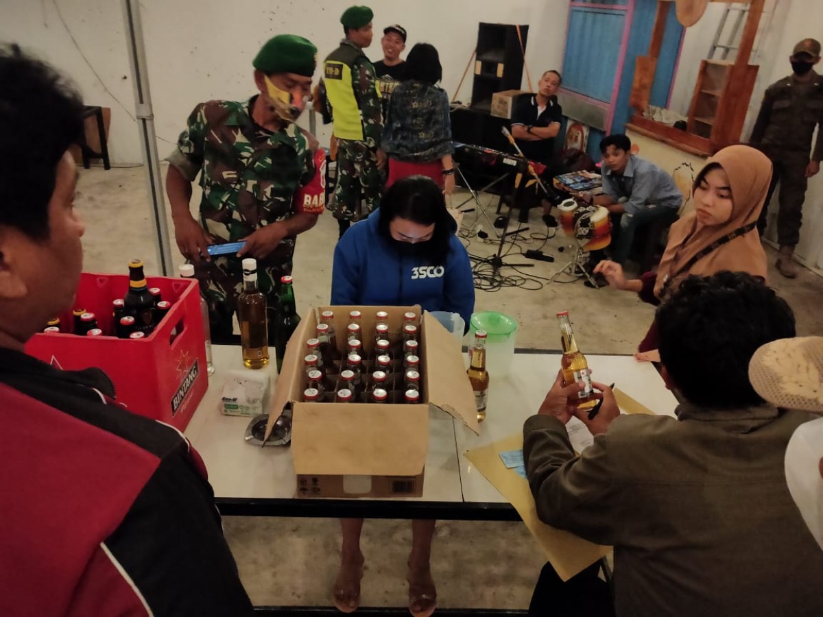 Polisi saat mengamankan puluhan botol miras. (foto: Rully Siregar for jatimnow.com)