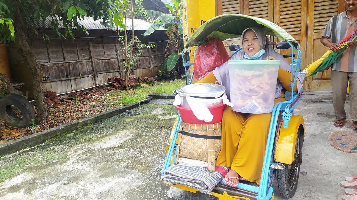 Wakinah, penjual nasi baronan di Lamongan saat berangkat beraktivitas. (foto: Adyad Ammy Iffansah/jatimnow.com)