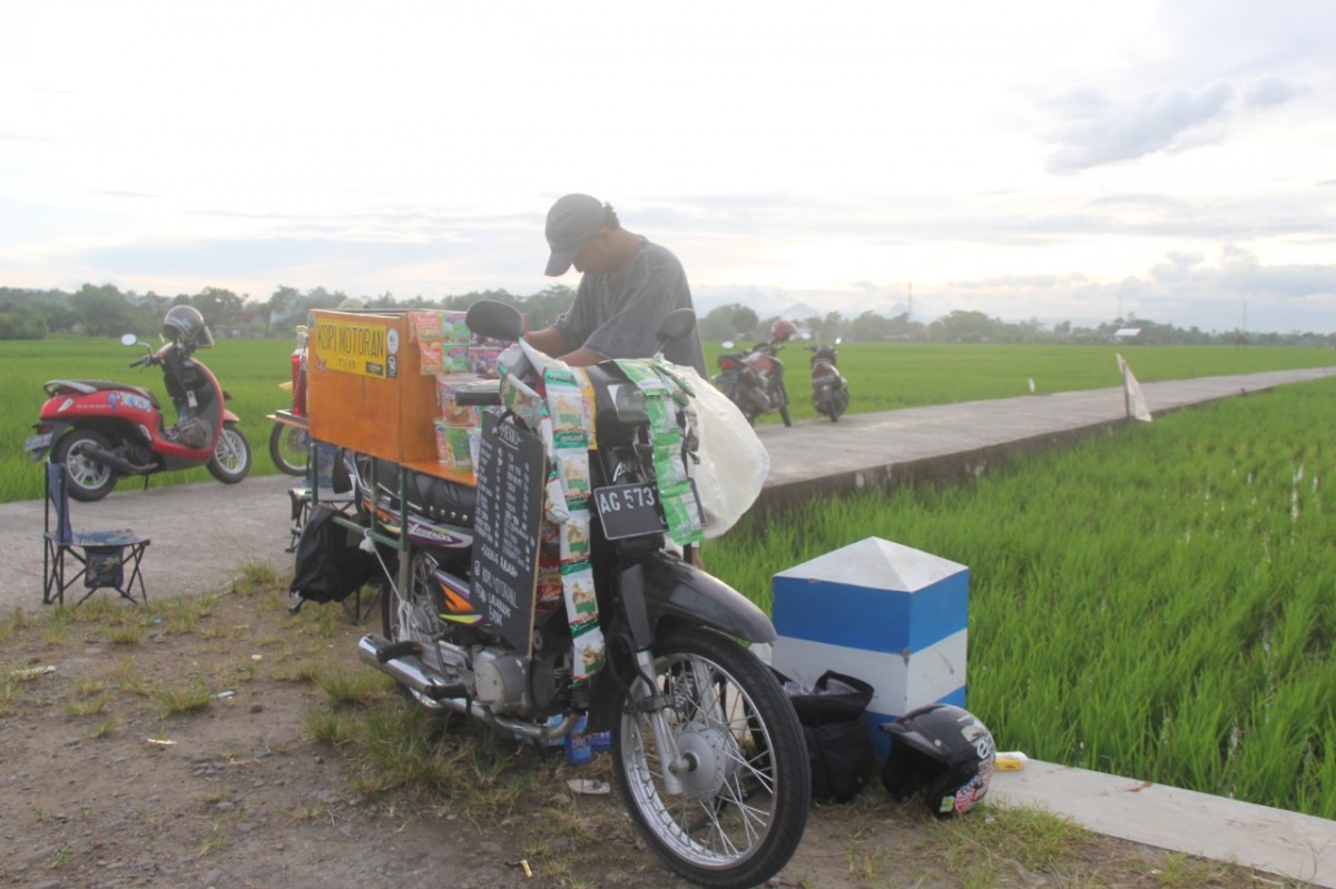 Yasfitama bersama sepeda motor yang diubah menjadi "warung" kopi. (Foto: Bramanta Pamungkas/jatimnow.com)