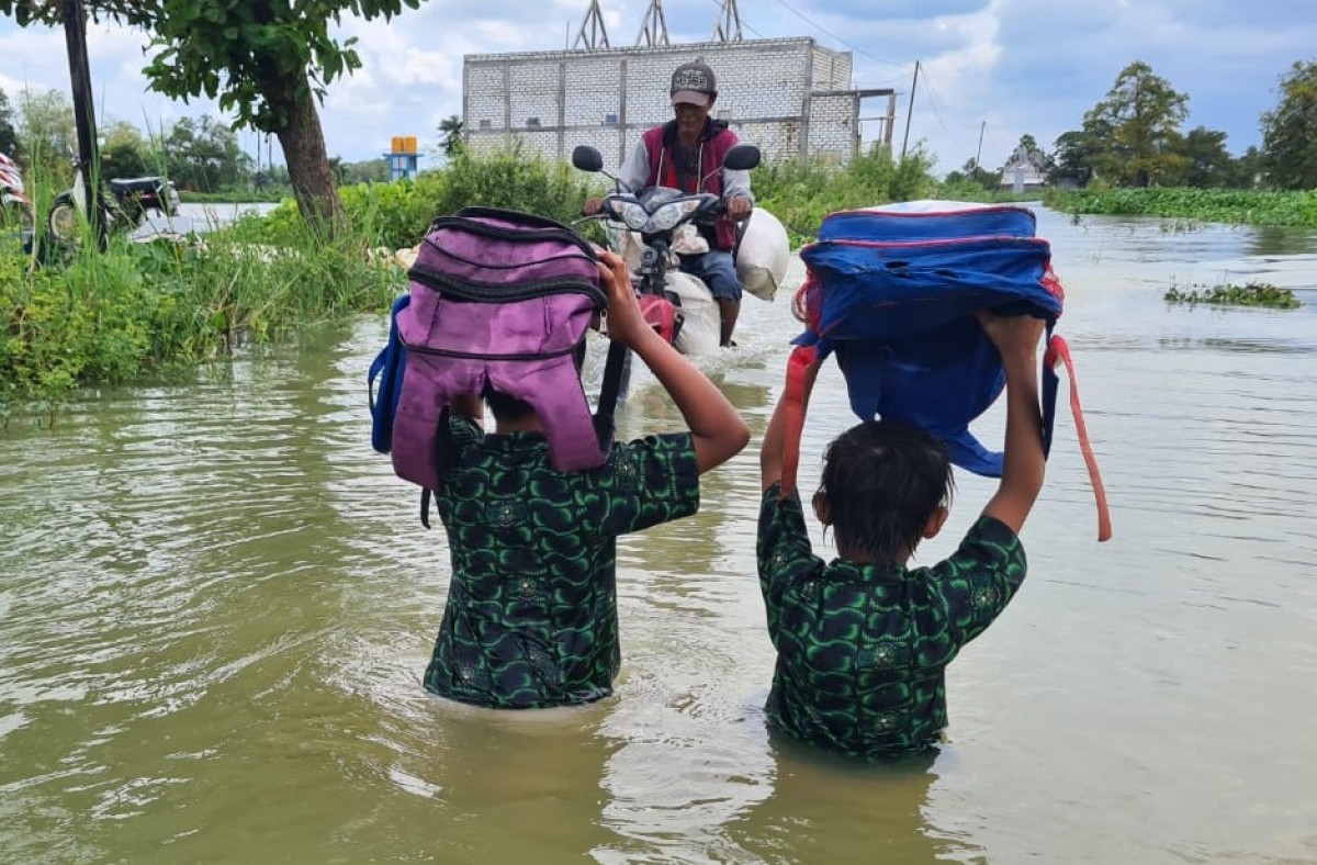 Pelajar di Desa Bojoasri, Kecamatan Kalitengah, Lamongan menerabas banjir untuk ke sekolah. (Foto : Adyad Ammy Iffansah/jatimnow.com)