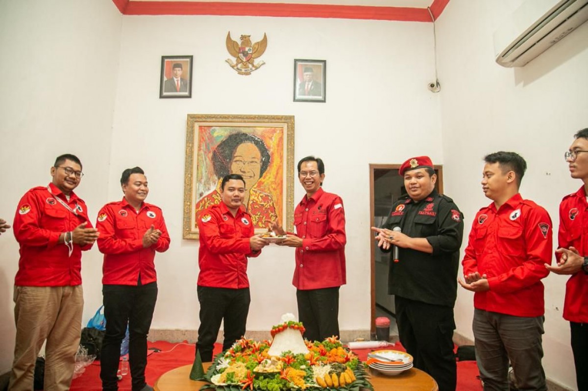 Ketua DPC PDI Perjuangan Kota Surabaya, Adi Sutarwijono menyerahkan potongan tumpeng kepada Ketua BMI, Fuad Bernadi. (foto: PDi Perjuangan Surabaya for jatimnow.com)