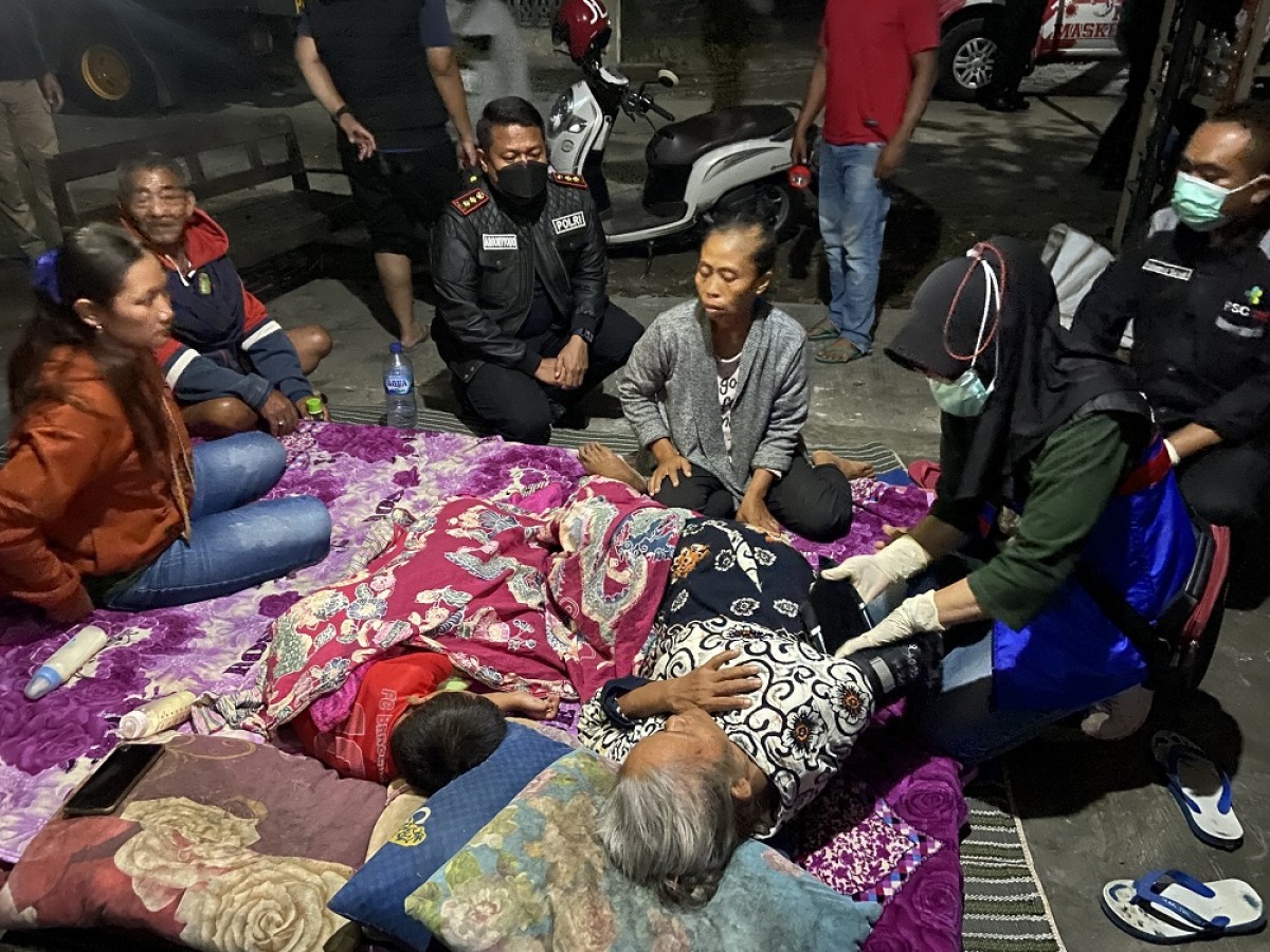 Sri Utami (duduk-tiga dari kanan) saat mengungsi di halaman rumah warga. (Foto: Yanuar Dedy/jatimnow.com)