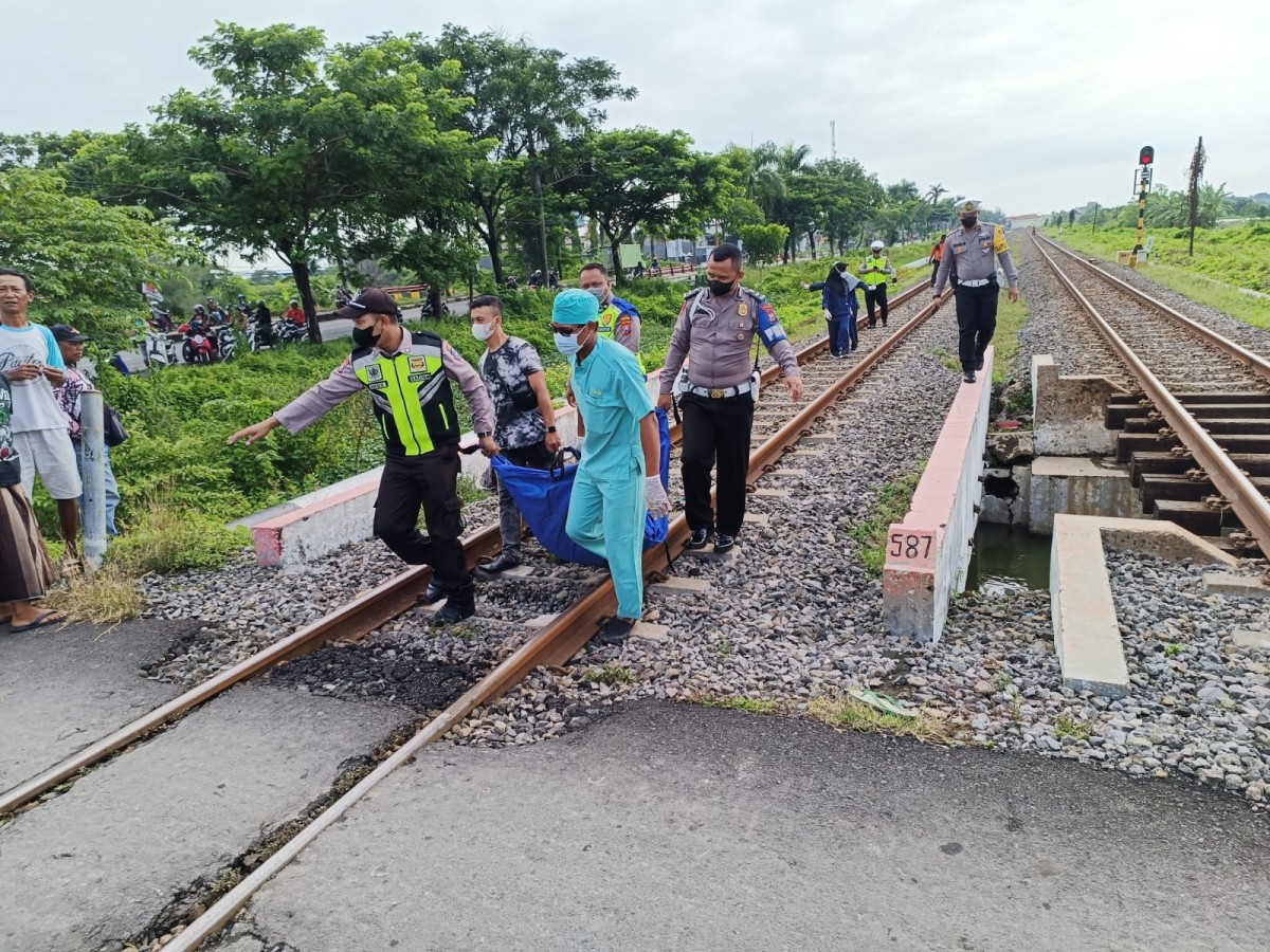 Proses evakuasi mayat pria misterius tewas di atas rek KA Lamongan. (Foto: Unit Gakkum Polres Lamongan for jatimnow.com)