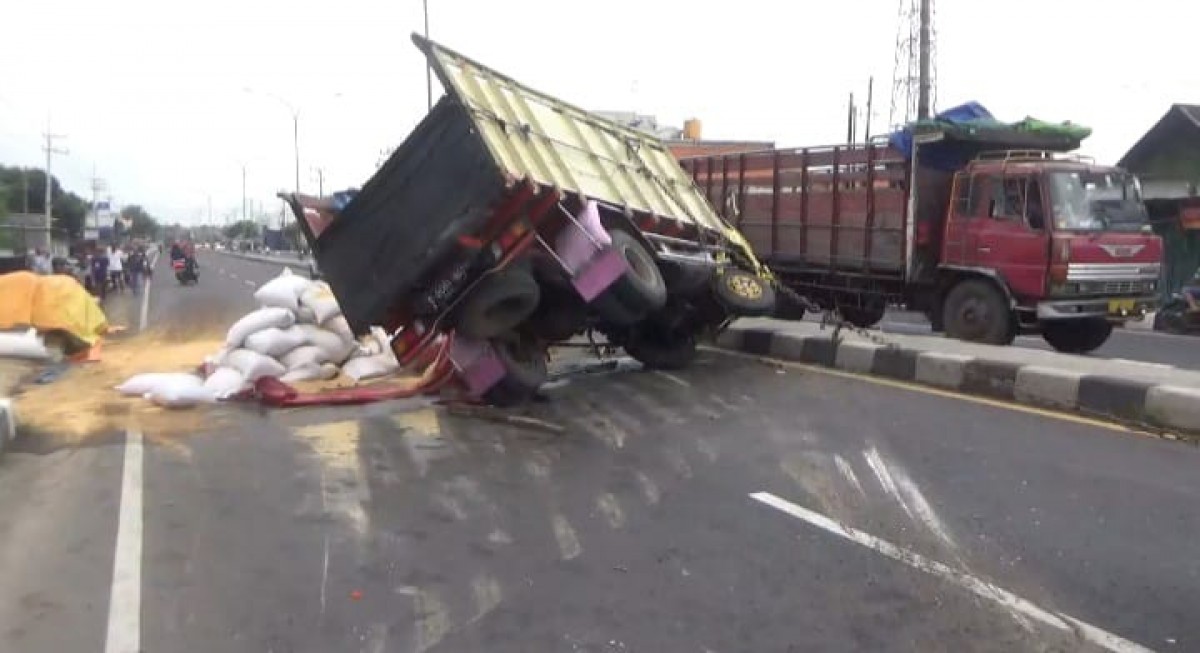 Truk muatan pakan benur saat terguling di jalan nasional Surabaya-Madiun. (Foto: Elok Aprianto/jatimnow.com)