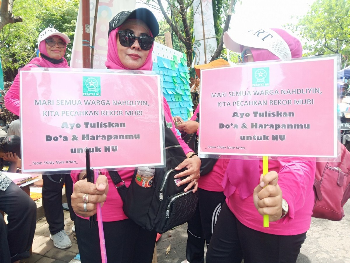 Dua orang Fatayat NU Sidoarjo menunjukkan papan berisi harapan untuk NU. (Foto: Zainul Fajar/jatimnow.com)