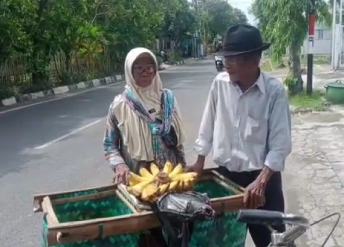 Pasutri lansia di Lamongan saat menjajakan dagangannya menyusuri jalan kota. (Foto: Adyad Ammy Iffansah/jatimnow.com)