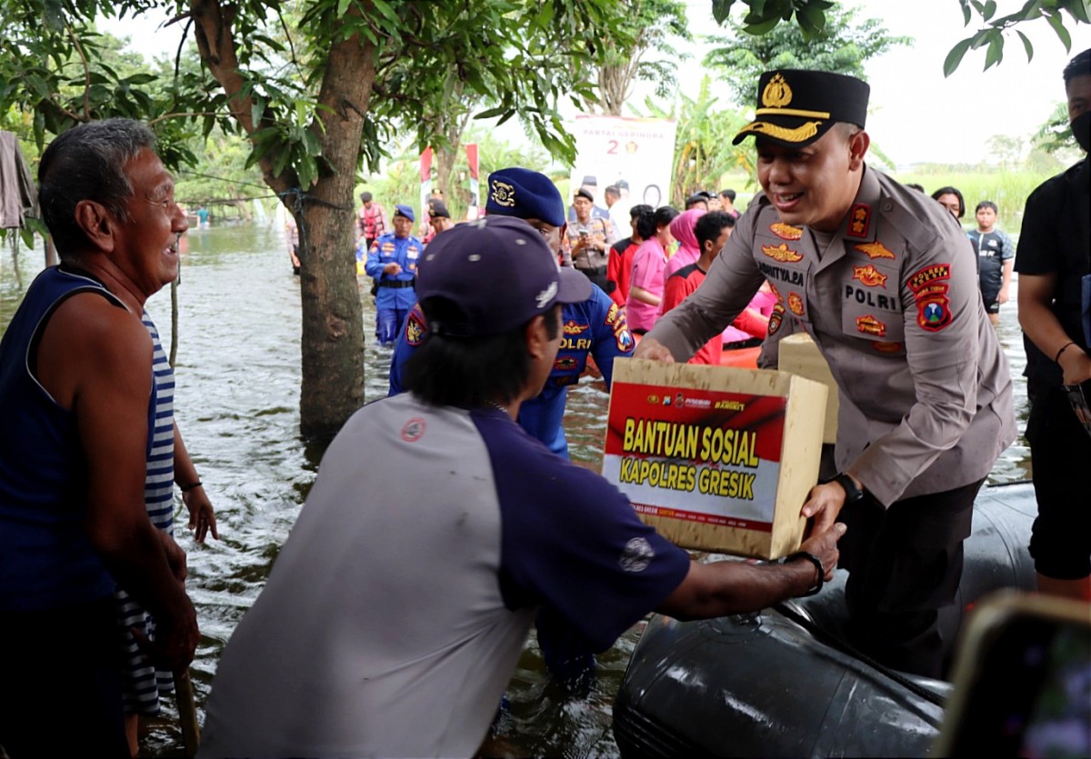 Kapolres Gresik, AKBP Adhitya Panji Anom saat memberikan bantuan pada warga terdampak banjir (Foto: Humas Polres Gresik)