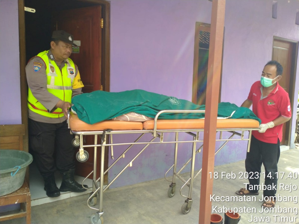 Petugas mengevakuasi jenazah pria dari dalam kamar indekos. (Foto: Polsek Jombang/jatimnow.com)