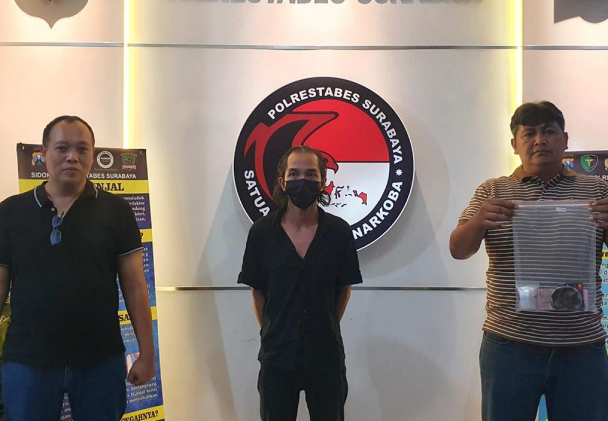 Anggota Polrestabes Surabaya menunjukkan barang bukti yang diamankan dari HM. (foto: Polrestabes Surabaya for jatimnow.com)