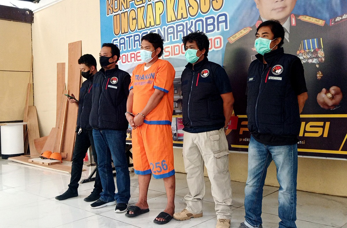 Pengedar narkoba berinisial MNA saat gelaran rilis di Polresta Sidoarjo. (foto: Zainul Fajar/jatimnow.com)