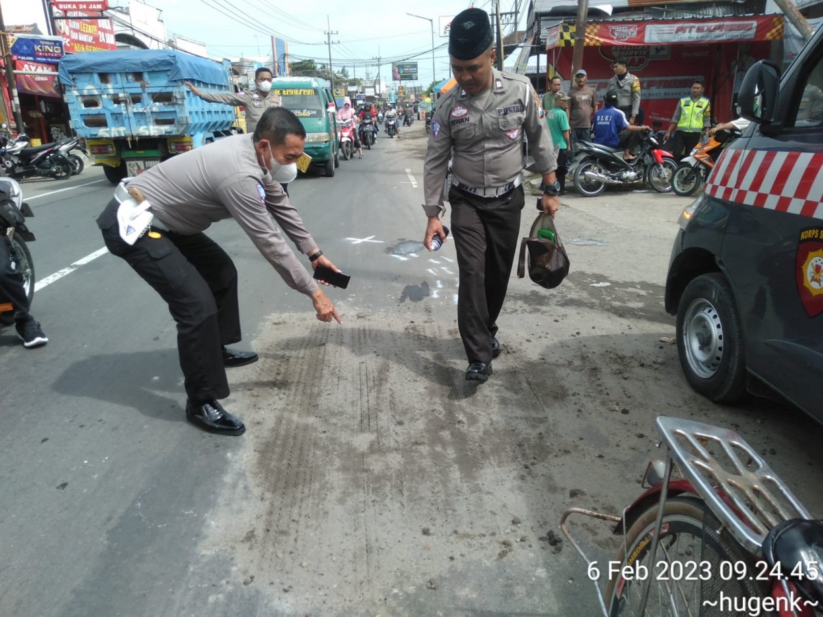 Polisi menunjukkan titik lokasi bocah berumur delapan tahun yang tewas dalam laka lantas. (foto: Elok APrianto/jatimnow.com)