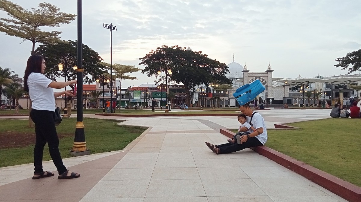 Pengunjung sedang duduk dan berfoto di Alun-Alun Kota Pasuruan. (Foto-foto: Moch. Rois/jatimnow.com)