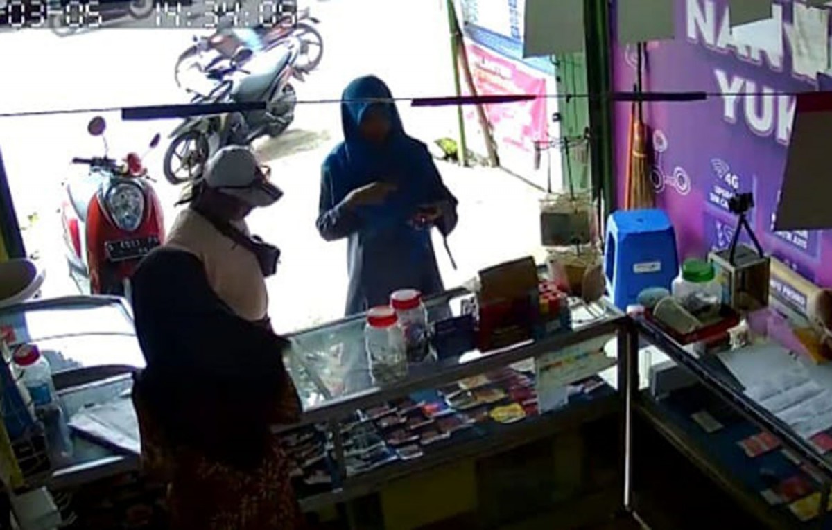 Pelaku dan korban saat tertangkap kamera CCTV yang ada di konter HP (Foto: Tangkapan layar video CCTV)