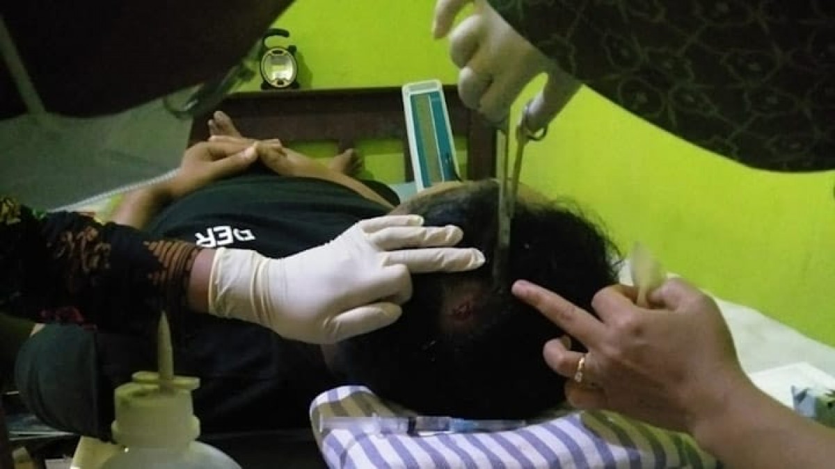 Seorang guru PJOK SDN 1 Kledung Pacitan mendapat perawatan setelah tertimpa genteng yang jatuh akibat lapuknya kondisi bangunan. (foto: Dian for jatimnow.com)