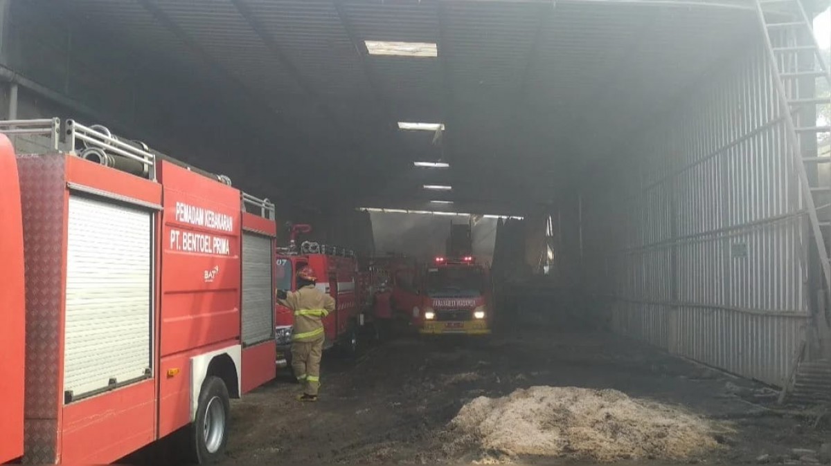 Petugas melakukan pembasahan kebakaran pabrik kayu. (Foto: Yanto for jatimnow.com)