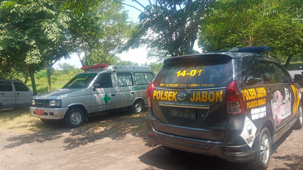 Mobil Polsek Jabon, Polresta Sidoarjo berada di lokasi tenggelamnya pemancing (Foto: Achmad Supriyadi/jatimnow.com)