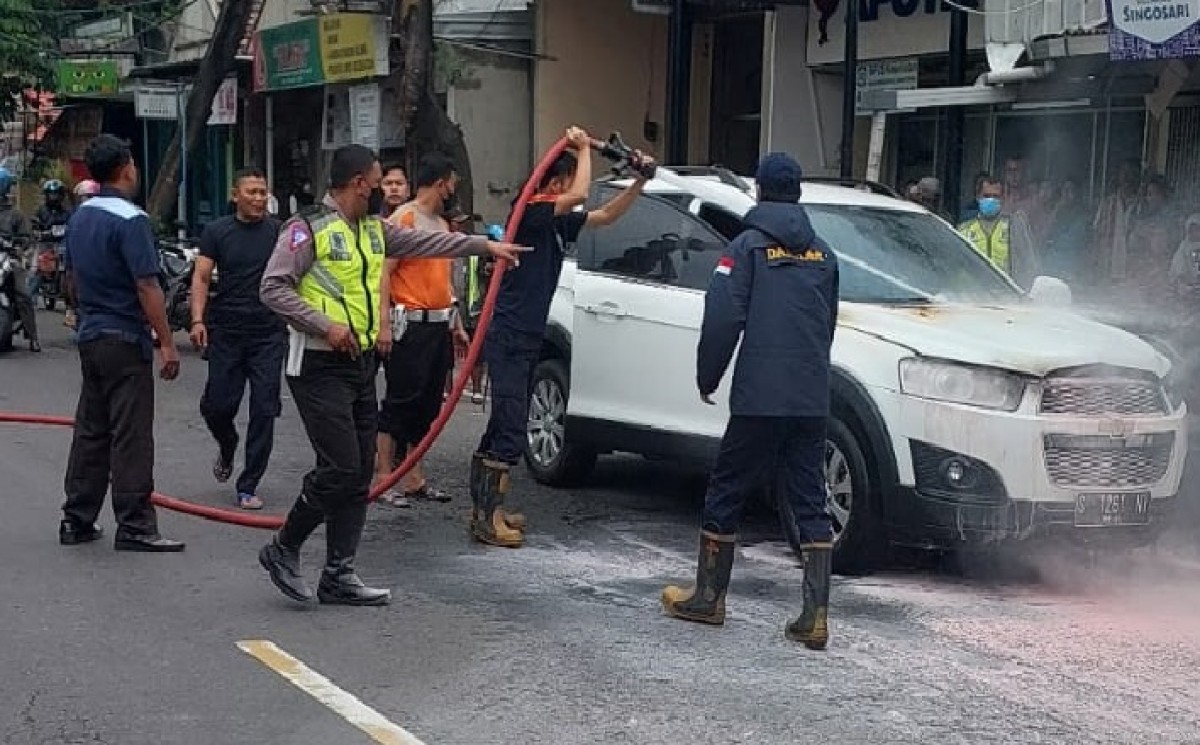 Mobil saat disemprot air oleh pemadam kebakaran. (Foto: PMK BPBD Kabupaten Mojokerto for jatimnow.com)