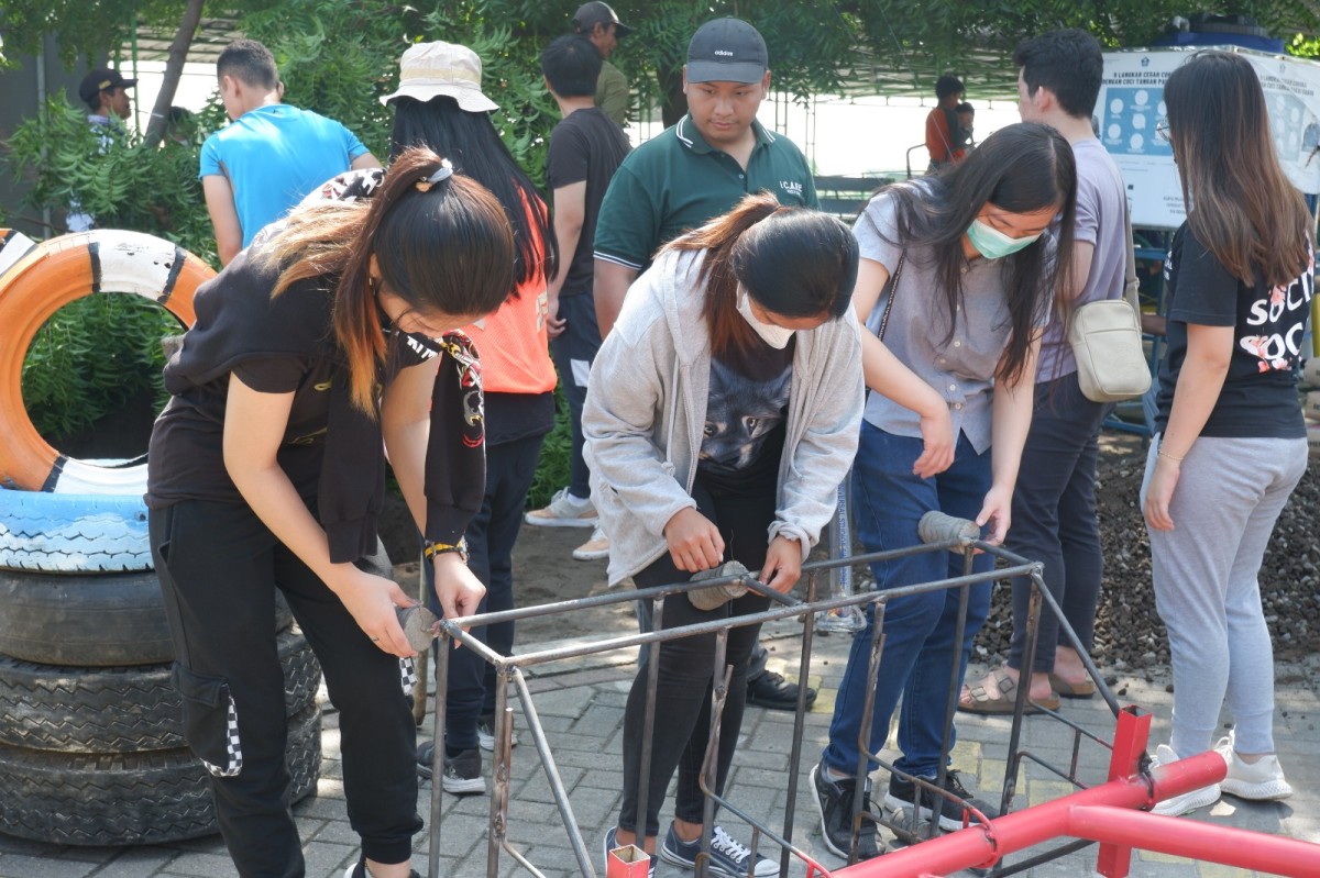 Para mahasiswi sedang memasang tahu beton untuk membuat pondasi dari spot foto. (Foto: Humas UK Petra for jatimnow.com)